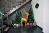 Christmas decoration in a hallway with stairs, featuring a golden reindeer, Christmas trees, and gift boxes. Náhled obrázku produktu