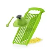 A green grater with a food pusher and shredded cheese on a white background. Produktbild-Vorschau