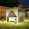 A garden gazebo set up for an evening event with table settings inside and lanterns outside. Náhled obrázku produktu