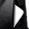 A close-up view of a black leather bag with a smartphone partially inserted into an exterior pocket. Náhľad obrázku produktu