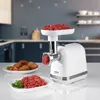 A white meat grinder is shown in a kitchen setting, with chopped meat in the hopper and ground meat on a plate in the foreground. Anteprima dell’immagine prodotto
