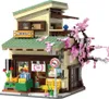 A detailed model of a Japanese-style building with a cherry blossom tree. Produktbild-Vorschau