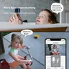 A split image showing a woman in a bathtub and a child on a tricycle, with a phone screen displaying a live feed. Náhled obrázku produktu