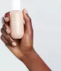 A hand holding a bottle of Elemis Superfood Glow Priming Moisturizer. Podgląd zdjęcia produktu