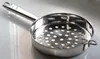 A stainless steel colander with a handle, resting on a reflective surface. Voir les images du produit
