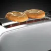 Two bagels are placed on a toaster rack, ready to be toasted. Podgląd zdjęcia produktu