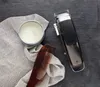 A hair clipper, comb, and hair product are arranged on a dark surface. Podgląd zdjęcia produktu