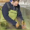 A man in waders is testing the water with a handheld device. Produktbild-Vorschau