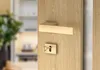 A close-up of a wooden door with a gold door handle and keyhole. Produktbild-Vorschau