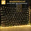 A net of fairy lights is draped over a fence or railing outdoors at night, with rain falling. Produktbild-Vorschau