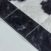 Close-up view of a black and white patchwork rug with visible stitching. Produktbild-Vorschau