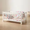 Ein weißes Puppenbett aus Holz mit Bettwäsche mit einem Produktbild-Vorschau 3