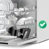 Close-up view inside a dishwasher showing stacked dishes, cutlery, and a black appliance on the bottom rack. A green checkmark graphic with a dashed line pointing to the bottom rack suggests correct placement. Voir les images du produit