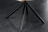 A close-up view of the black metal legs of a chair on a dark wooden floor. Produktbild-Vorschau