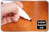 A hand is using a white marker to touch up a scratch on a wooden surface. Anteprima dell’immagine prodotto