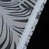 A close-up view of a sheer curtain with a leaf pattern and a header tape. Produktbild-Vorschau