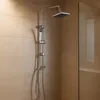 A modern shower system with a square overhead shower head and a handheld shower head, mounted on a vertical bar against a tiled wall. Produktbild-Vorschau