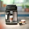 A fully automatic espresso machine with two cups of coffee and a glass of milk. Produktbild-Vorschau