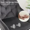 Close-up of a gray velvet bar stool with a hand pressing into a thick sponge cushion, highlighting comfort and breathability. Produktbild-Vorschau
