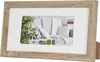 A wooden picture frame with a white mat and a picture of a living room scene inside. Produktbild-Vorschau