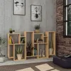 A wooden bookshelf filled with books and decorative items, placed against a textured gray wall and a brick wall. Podgląd zdjęcia produktu