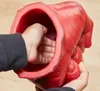 A child's hand is inserted into a large, red, Hulk-like fist-shaped object. Anteprima dell’immagine prodotto