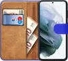 A book-style phone case with a phone inserted, showing cards and cash inside. Produktbild-Vorschau