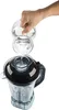 A hand is pouring liquid from a glass container into a blender. Podgląd zdjęcia produktu