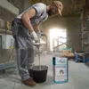 A construction worker is mixing plaster in a bucket with a power mixer in a room under renovation. Produktbild-Vorschau
