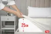 A person is putting a fitted sheet on a mattress, showing the depth of the sheet. Produktbild-Vorschau