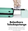 A person's legs and feet are shown standing on a platform that is part of a suitcase handle, demonstrating its strength. The suitcase is mint green. Produktbild-Vorschau