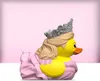 A side profile of a Glinda the Good Witch themed rubber duck toy, wearing a crown and a pink dress, set against a pink gradient background. Náhled obrázku produktu