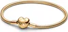 A gold Pandora bracelet with a heart-shaped clasp is displayed on a white background. Podgląd zdjęcia produktu