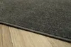 A close-up view of a gray rug with a stitched edge, lying on a wooden floor. Produktbild-Vorschau