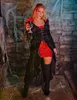 A woman in a vampire costume holding a goblet in a dungeon-like setting. Anteprima dell’immagine prodotto