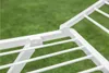 A close-up view of a white plastic drying rack against a blurred green background of grass. Náhled obrázku produktu