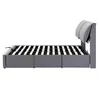 A side view of a gray upholstered bed frame with a slatted mattress support. Produktbild-Vorschau