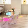 A modern, iridescent acrylic coffee table with flowers in a vase, placed on a wooden floor in a living room setting. Anteprima dell’immagine prodotto