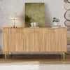 A wooden sideboard with arched doors and gold legs is displayed in a room with decorative items on top. Náhled obrázku produktu