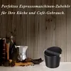 A knock box and coffee accessories are displayed on a shelf with a wooden background. Produktbild-Vorschau