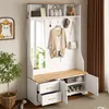 A hallway storage unit with a bench, mirror, hooks, drawers, and shoe storage, decorated with a plant and a cat painting. Produktbild-Vorschau