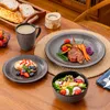 A table setting with a meal, including a main course, salad, bread, and a drink. Produktbild-Vorschau