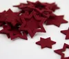 A pile of red felt star-shaped confetti on a white background. Produktbild-Vorschau