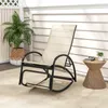 A rocking chair on a patio with a plant and a side table. Náhled obrázku produktu