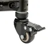 A close-up view of a black caster wheel with a brake mechanism attached to a dark metal pole. Podgląd zdjęcia produktu