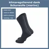 A pair of dark gray socks is shown against a white background, with a text overlay detailing the product's features. Produktbild-Vorschau