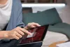 A person is holding and interacting with a tablet device. Produktbild-Vorschau