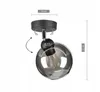 A black adjustable ceiling lamp with a smoked glass shade and an exposed E27 bulb, shown against a white background with dimensions indicated. Produktbild-Vorschau