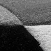 A close-up view of a textured carpet with geometric patterns in black, white, and gray. Produktbild-Vorschau
