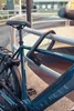 A close-up of a bicycle lock securing a bicycle to a railing. Produktbild-Vorschau
